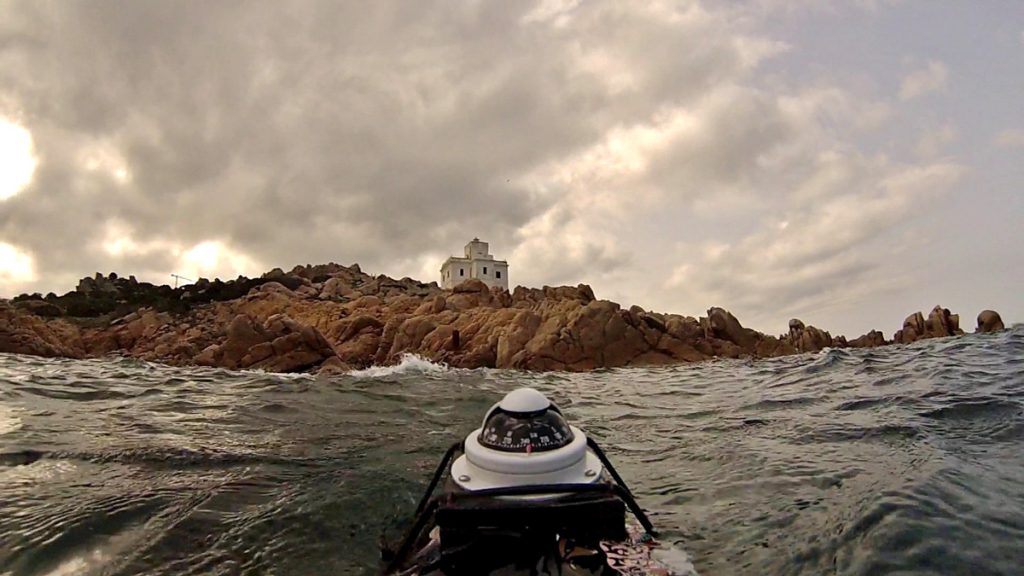 Vista dal mare del faro di Punta Sardegna con bussola su scooter subacqueo in primo piano, durante una missione esplorativa